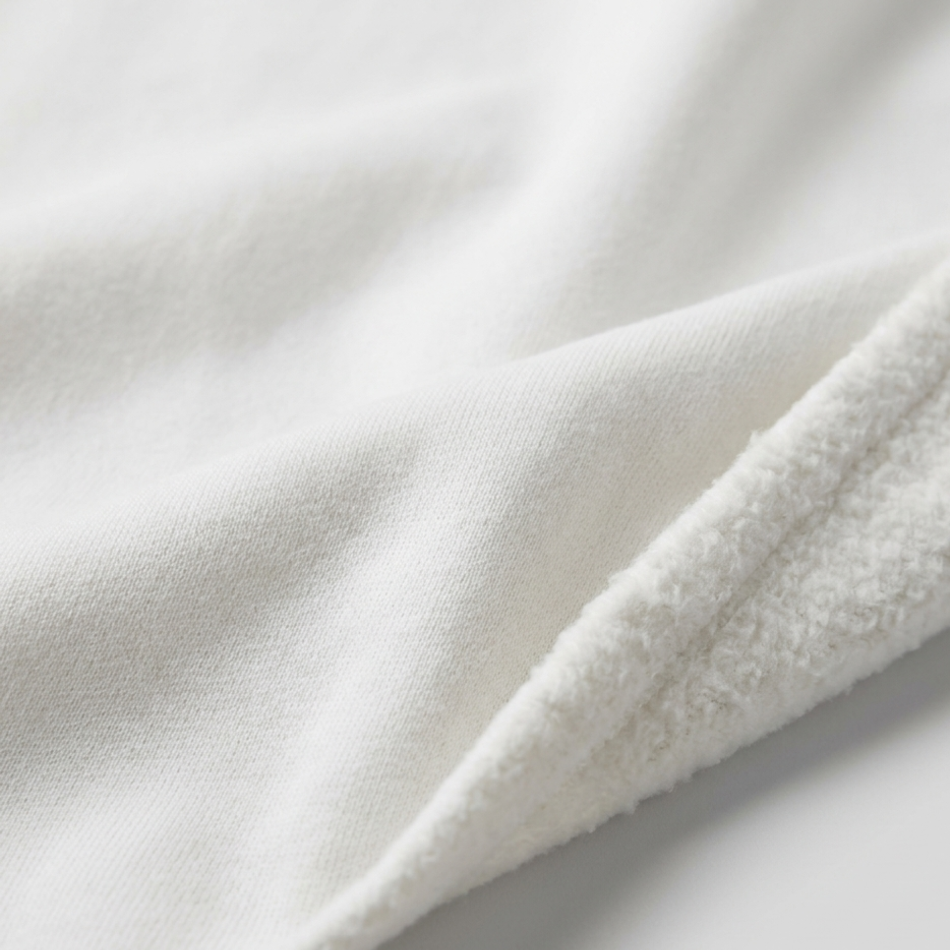A close-up of Everglow: Silent Growth fleece hoodie fabric reveals a smooth side and a fluffy, textured side, highlighting its warmth and comfort.