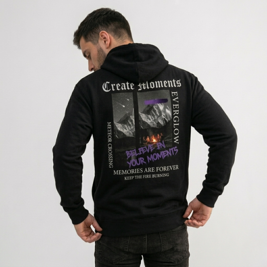 A man stands with his back to the camera in a cozy Create Memories Hoodie, featuring a mountain graphic and inspiring text like "Create Moments," "Everglow," and "Believe in Your Moments" on the back, against a plain white background.