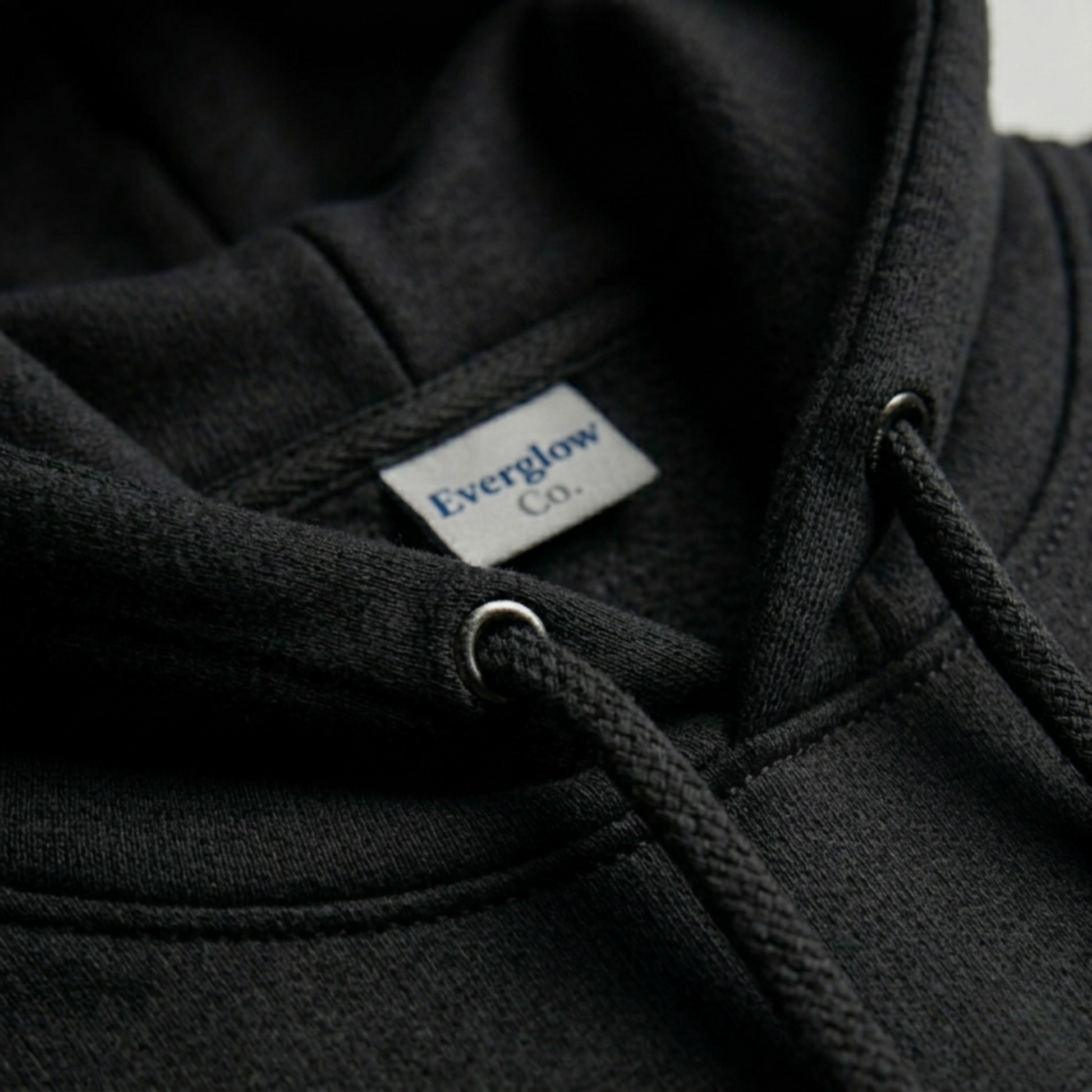 Close-up of a cozy fleece Create Memories Hoodie, highlighting the hood drawstrings and a white label with text stitched inside the neckline.