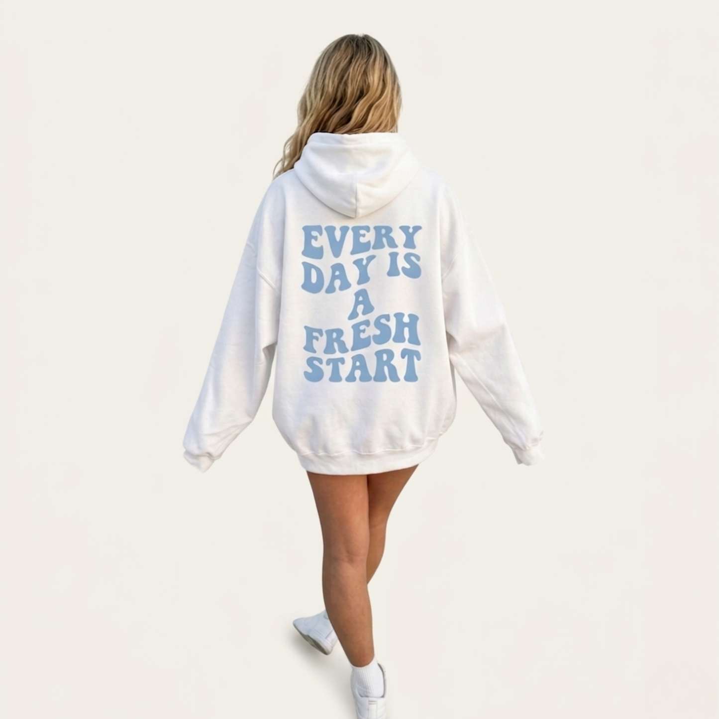 A person with long blonde hair wears the Fresh Start Hoodie with blue "EVERY DAY IS A FRESH START" text, standing against a plain light background.