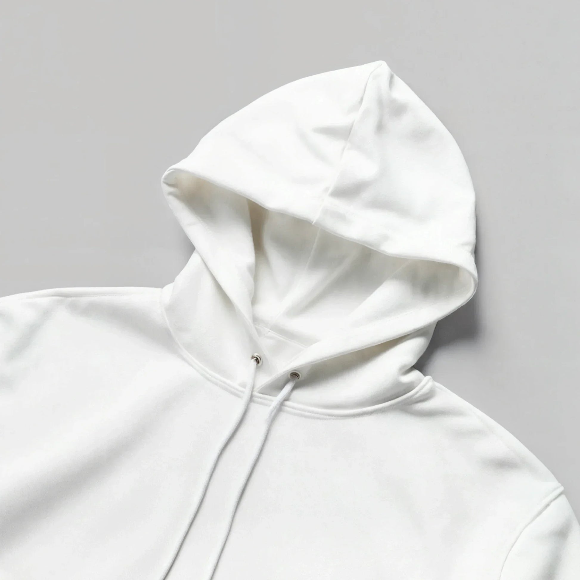 Unisex white hoodie with drawstrings, minimalist streetwear flat lay on gray background