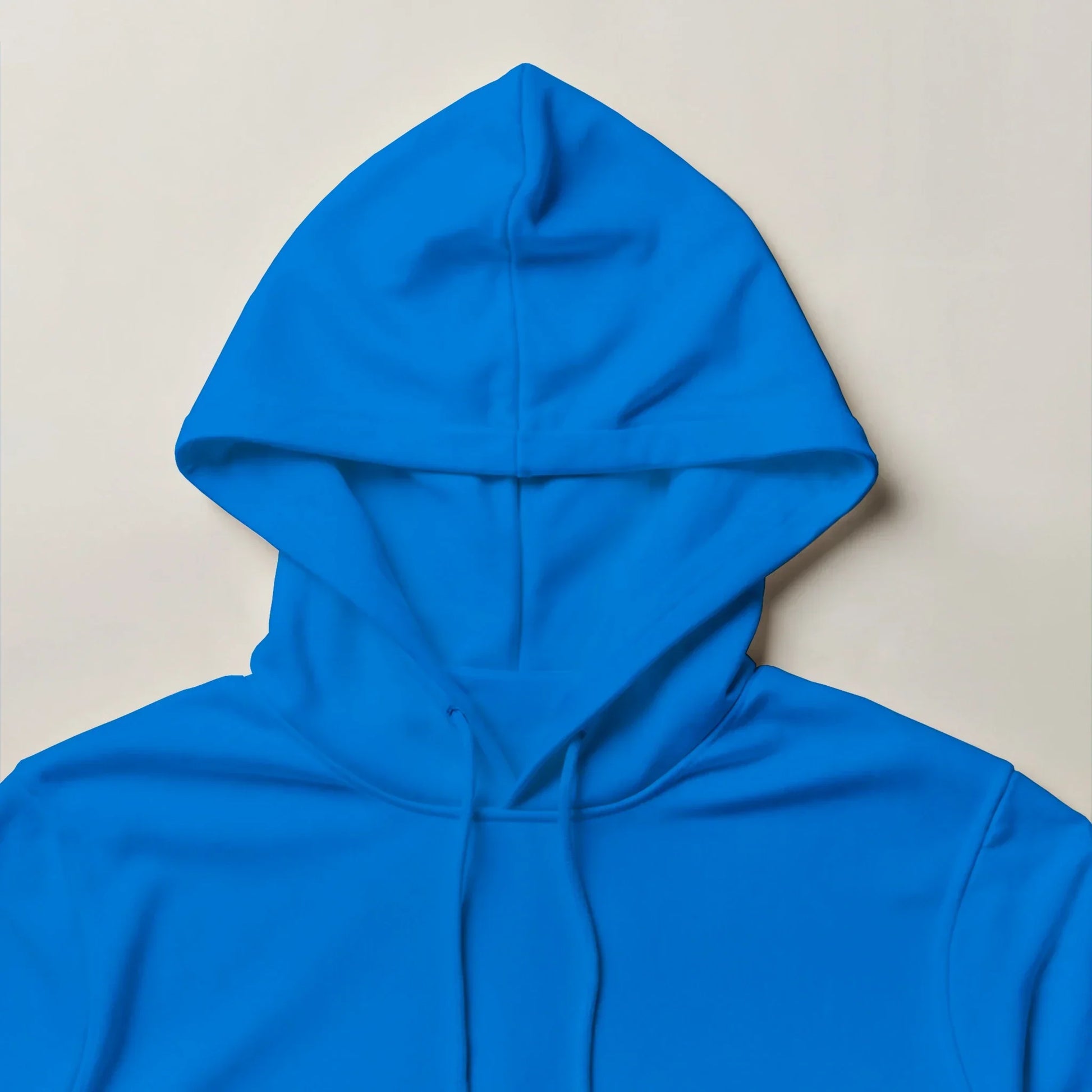 Bright blue unisex hoodie with drawstrings, minimal streetwear style on neutral background